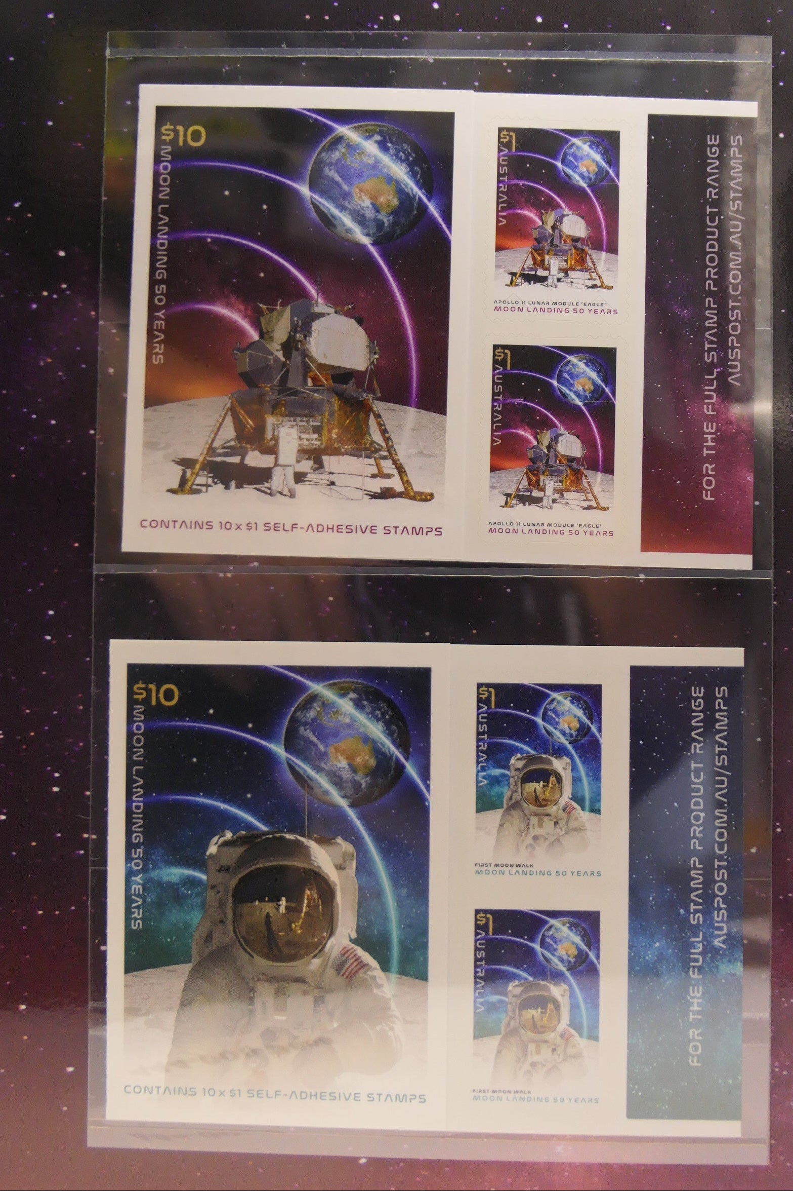 Two sheets of stamps featuring space-themed designs on a reflective surface.