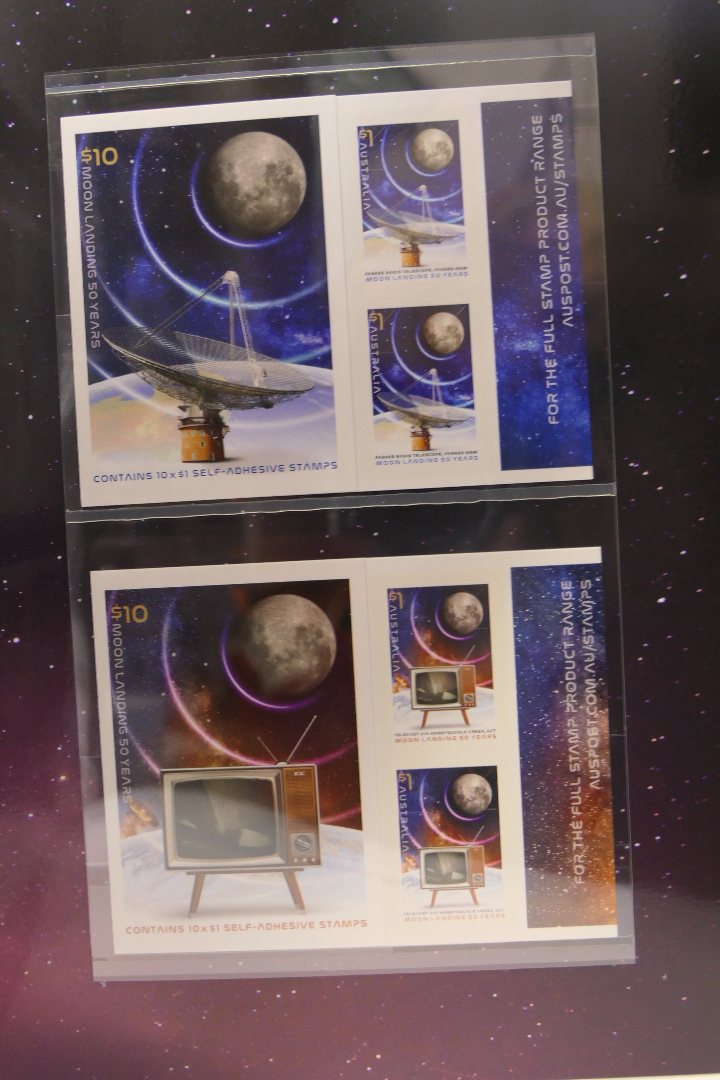 Two space-themed stamps in protective clear packaging on a dark background.
