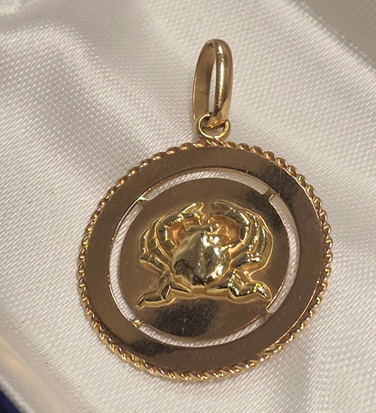 18 ct Yellow gold Cancer zodiac pendant featuring a polished crab motif centered inside a textured rope-edge circular frame.