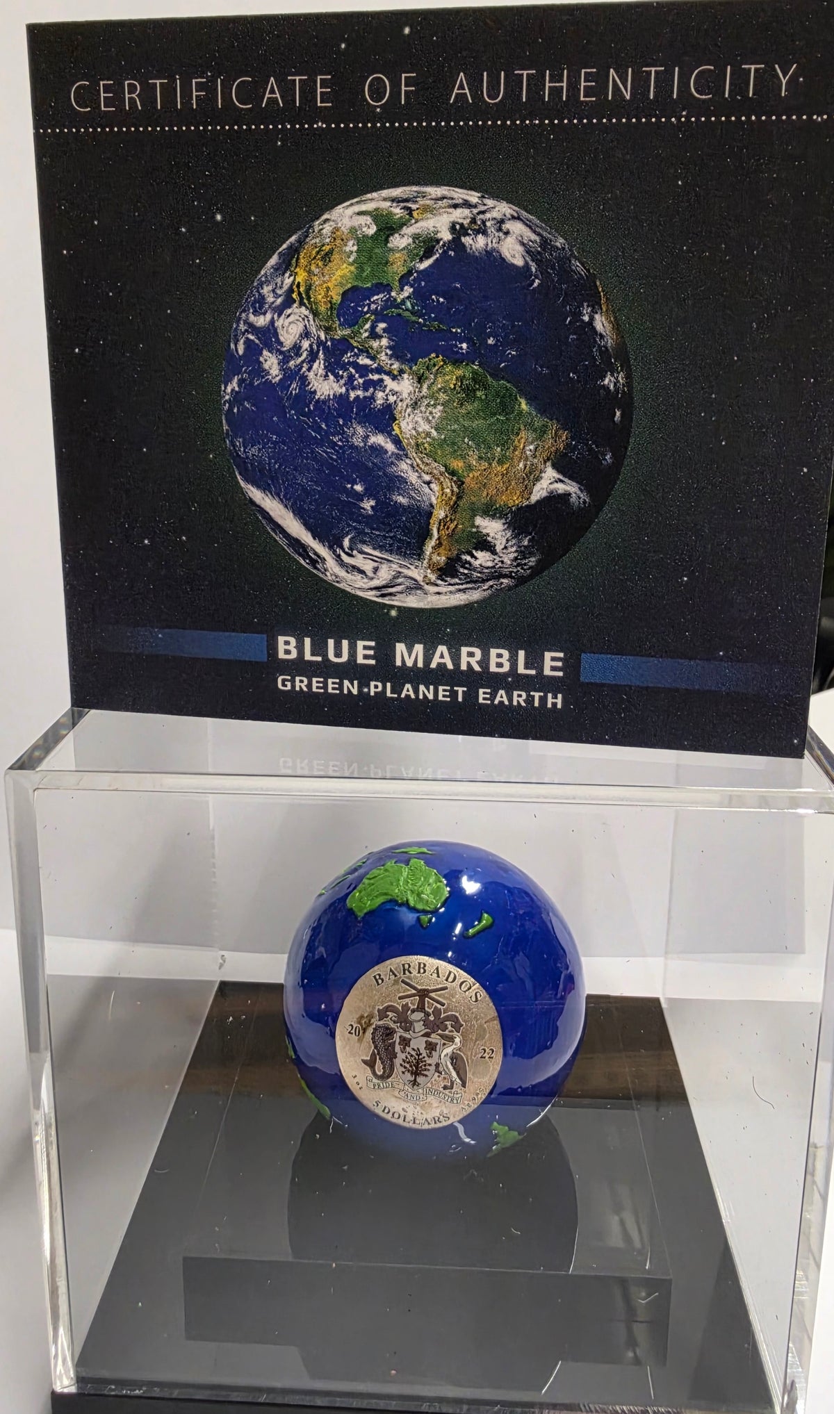 2022 Barbados $5 Blue Marble Planet Earth 3 oz Silver Spherical Coin featuring blue enamel oceans and gold-plated landmasses.
